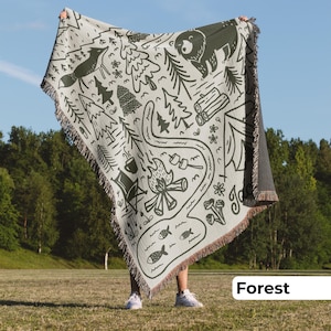 Fringed custom name blanket for campers and travel families, featuring a rustic campfire-inspired design that makes an ideal gift for outdoorsy adventures.
