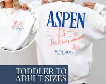 May include: White sweatshirt with the word "ASPEN" in blue on the back, along with a red ski lift graphic. The front features a small red ski and tree design. Text on the front and back reads "SMITH FAMILY SKI TRIP 2025".