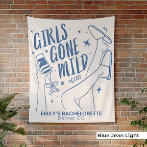May include: A light-colored wall tapestry with blue line art. The text "GIRLS GONE MILD" is displayed, along with "est 2025" and "EMILY'S BACHELORETTE Denver, CO". The design includes illustrations of a person holding a drink and legs in heels.