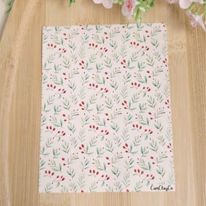 Könnte beinhalten: Ein weißes Blatt Papier mit einem sich wiederholenden Muster aus grünen Blättern und roten Beeren. Das Papier trägt den Text "CamiClayCo" in der rechten unteren Ecke.