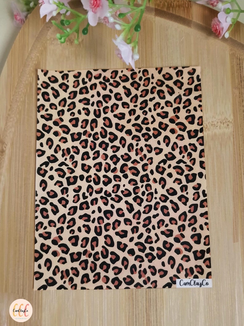 May include: A sheet of pink and black leopard print vinyl with the text "CamClayCo" in the bottom right corner.