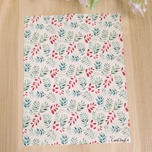 Peut inclure: Un fond blanc avec un motif répété de feuilles vertes et de baies rouges. Le motif est un design aquarelle. Le texte "CamiClayCo" est dans le coin inférieur droit de l'image.