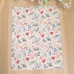 Peut inclure: Un fond blanc avec un motif répétitif de feuilles et de baies rouges, bleues et vertes. Le motif est un design aquarelle. Le texte "CamiClayCo" est dans le coin inférieur droit de l'image.