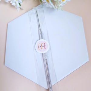 Może przedstawiać: Srebrne narzędzie do rzeźbienia z zaokrąglonym końcem, zapakowane w przezroczystą plastikową torebkę. Narzędzie jest oznaczone tekstem "CandClayCo."