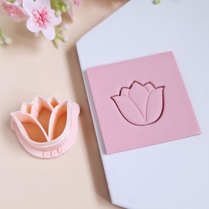 Op de afbeelding: Een roze siliconen mal met een tulpenontwerp. De mal wordt gebruikt voor het maken van fondant- of gum paste-decoraties voor taarten en cupcakes.