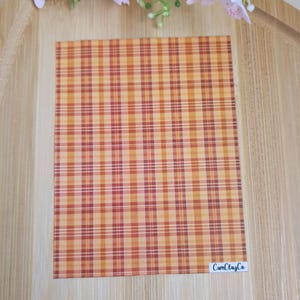 Peut inclure: Une feuille de papier à motifs à carreaux orange et rouge avec le texte "CamClayCo" dans le coin inférieur droit.