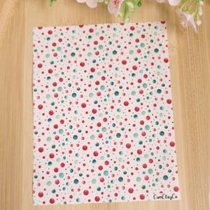 Peut inclure: Tissu blanc avec un motif répétitif de points d'aquarelle rouge et vert. Le tissu porte le texte "CamClayCo" dans le coin inférieur droit.