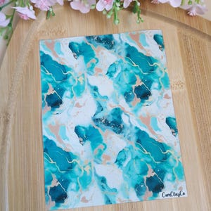 May include: A sheet of teal, white, and gold marbled vinyl with the text "CamClayCo" in the bottom right corner.