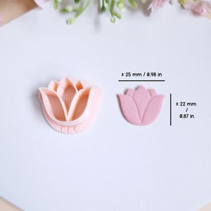 Op de afbeelding: Een roze polymer clay tulpenbloem met een gedetailleerd ontwerp. De bloem is ongeveer 22 mm in diameter. Er is ook een siliconen mal van hetzelfde tulpenontwerp te zien. De mal is ongeveer 25 mm in diameter.