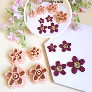 Puede incluir: Un juego de cortadores de arcilla de plástico color melocotón claro con forma de flor en varios tamaños junto a flores de arcilla de color granate oscuro con centros de purpurina dorada. La imagen incluye un recuadro circular con texto.