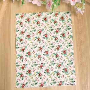 Peut inclure: Fond blanc avec un motif répété de feuilles de houx vertes et de baies rouges. Le texte "CamClayCo" est dans le coin inférieur droit.