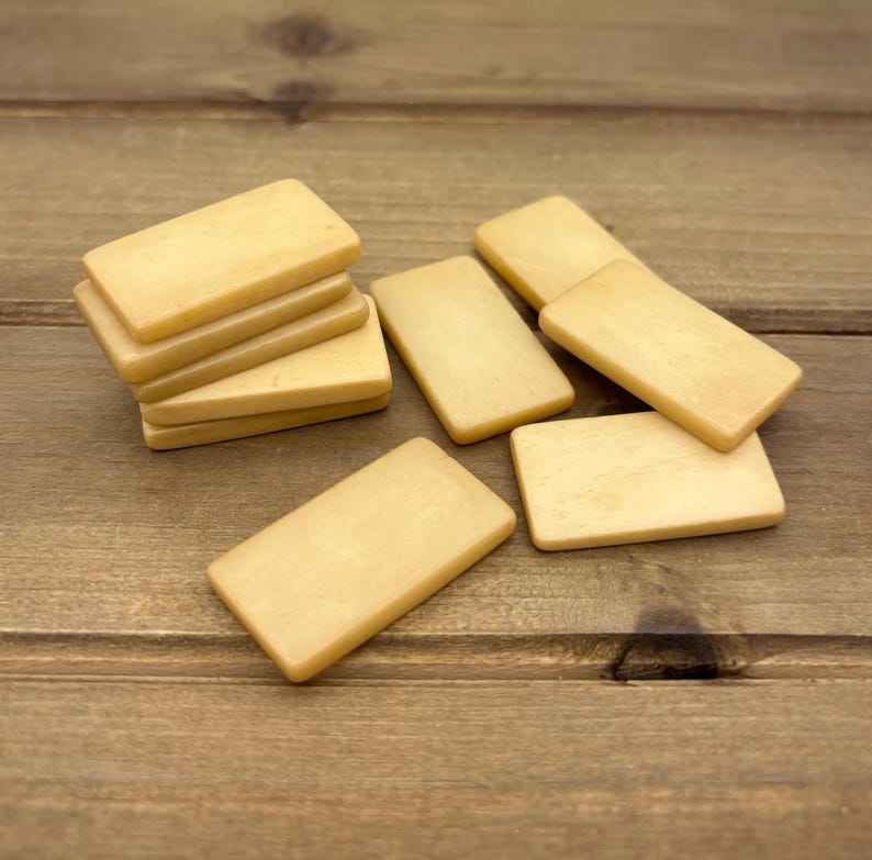 Puede incluir: Una pila de seis fichas rectangulares de madera de color marr&oacute;n claro. Las fichas est&aacute;n dispuestas en una pila con la ficha superior mirando hacia la c&aacute;mara. Las fichas son lisas y tienen un acabado ligeramente brillante.