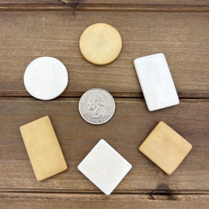 Puede incluir: Seis formas de madera en varios tama&ntilde;os y colores. Hay dos c&iacute;rculos blancos, un cuadrado blanco, un rect&aacute;ngulo blanco y dos rect&aacute;ngulos de color canela. Se incluye una moneda de veinticinco centavos de d&oacute;lar estadounidense de plata para la escala.