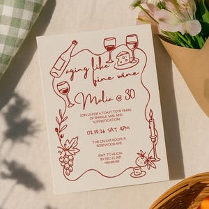 May include: A cream-coloured invitation with red line art featuring wine glasses, a bottle, and grapes. The text reads "Aging like fine wine Malia @ 30" and includes event details. A bouquet of flowers is in the background.