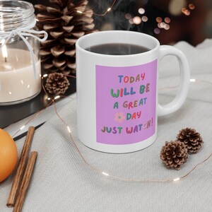 May include: White ceramic mug with a purple background and colorful text that reads "Today will be a great day! Just watch!"