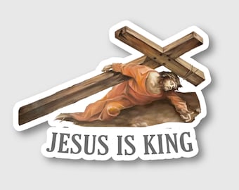 Puede incluir: Una pegatina con una pintura de Jesús llevando una cruz de madera. El texto "JESUS IS KING" está impreso debajo de la imagen.