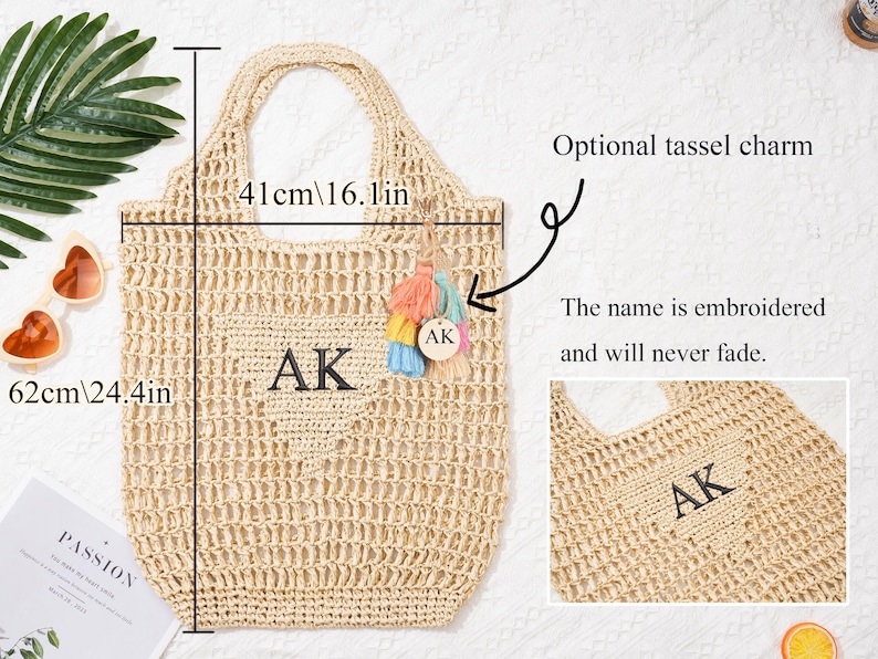 Puede incluir: Bolso tote tejido beige, de 62 cm de alto y 41 cm de ancho, con las iniciales "AK" bordadas. Incluye un charm de borla opcional. El texto "El nombre est&aacute; bordado y nunca se desvanecer&aacute;" es visible.