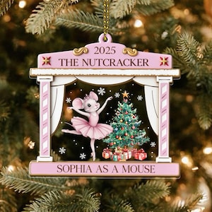 May include: A pink and white Christmas ornament featuring a ballerina mouse in a pink tutu, dancing in front of a Christmas tree. The ornament reads "2025 The Nutcracker" and "Sophia as a Mouse."