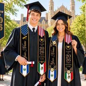 Puede incluir: Dos graduados con togas y birretes negros posan al aire libre. Llevan estolas de graduación con el texto "Your Name", "Class of 2026" y el nombre de la escuela. Una estola presenta la bandera estadounidense, la otra la bandera mexicana. Banners con "Class of 2026" y "Congrats Grads".