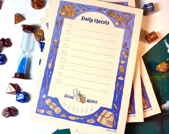 Op de afbeelding: Een stapel printbare dagelijkse takenlijsten met een blauwe en bruine rand met een rugzak, een slaapzak, een vis en een muis. De tekst "Daily Quests" staat bovenaan de lijst. De lijst heeft een sectie onderaan die "Drink Water" zegt met een muis en waterdruppels.
