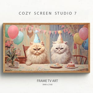 以下が含まれることがあります： パーティーハットをかぶった2匹の猫が、ケーキと風船のあるテーブルに座っている額入りのデジタルアートプリント。アートワークは、お祝いをテーマにしており、「COZY SCREEN STUDIO 7」と「FRAME TV ART」の文字が入っています。