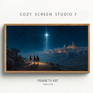 May include: A framed digital art print depicts a nighttime scene with three figures on camels approaching a city under a bright star. The artwork is set against a dark blue sky with the text "COZY SCREEN STUDIO 7" and "FRAME TV ART".