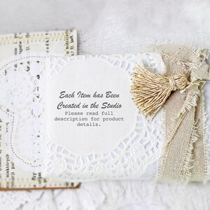 May include: A white gift box wrapped in burlap and lace with a small, beige tassel. The box has a white label with the text "Each Item has Been Created in the Studio. Please read full description for product details."