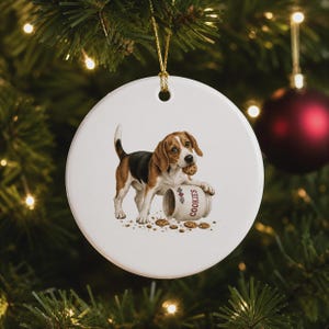 Peut inclure: Une décoration ronde en céramique blanche représentant un chien beagle marron, noir et blanc tenant un cookie aux pépites de chocolat dans sa gueule. Le chien est à côté d'un pot à biscuits blanc marqué COOKIES avec des miettes éparpillées.