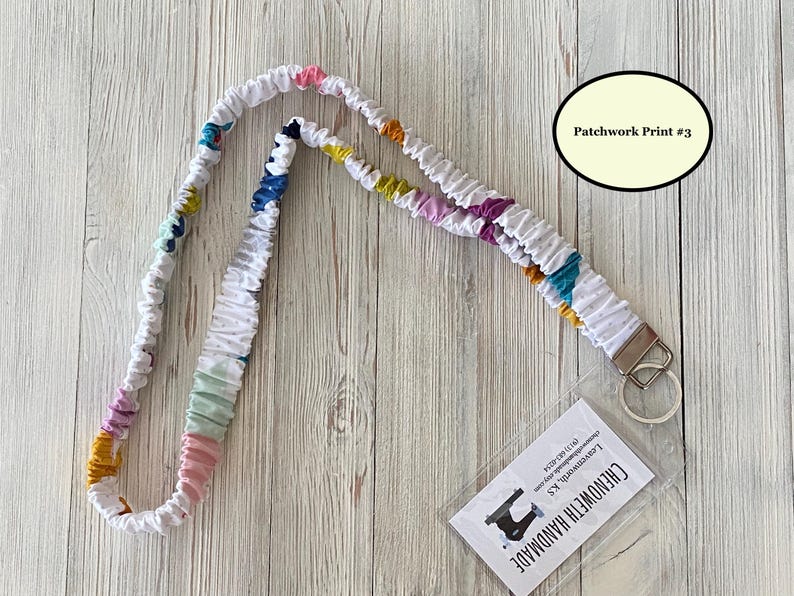Puede incluir: Cord&oacute;n de tela blanco con estampado de patchwork en varios colores, incluyendo rosa, azul, amarillo y morado. El cord&oacute;n tiene un cierre met&aacute;lico y una etiqueta transparente con el texto "Chenoweth Handmade" y "Patchwork Print #3".