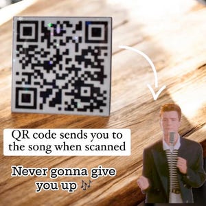 May include: A QR code on a white background with black squares. The text below the code reads "QR code sends you to the song when scanned" and "Never gonna give you up" with musical notes.