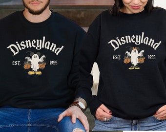 May include: Black sweatshirts with a vintage Disneyland logo and a ghost holding jack-o'-lanterns. The text reads "Disneyland Est. 1955".