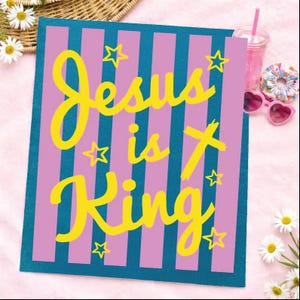 A colorful sign with the text "Jesus is King" in yellow and pink letters, surrounded by stars and flowers.