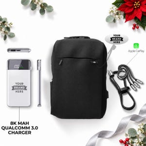 May include: A black backpack, a white power bank with a digital display showing 100 and the text YOUR BRAND HERE, and a multi-connector charging cable with a circular YOUR BRAND HERE logo. The text 8K MAH QUALCOMM 3.0 CHARGER is visible.