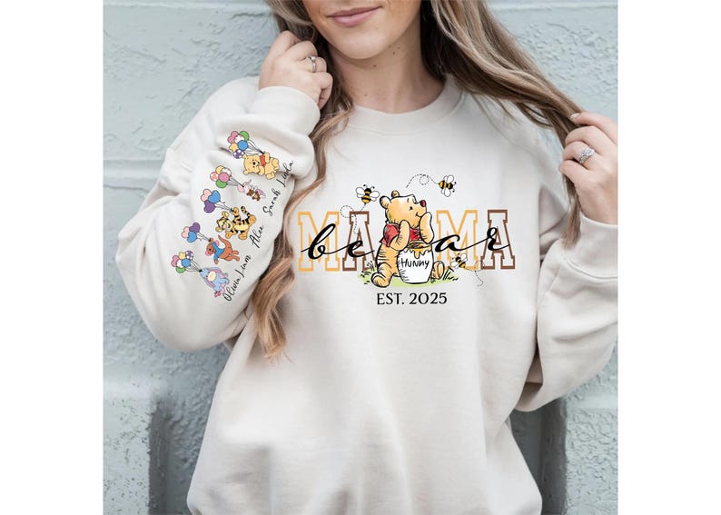 A woman wearing a white sweatshirt with a Winnie the Pooh design and text on it.