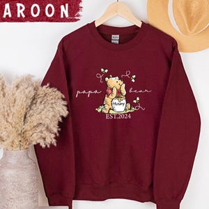 a red sweatshirt with a picture of a bear on it