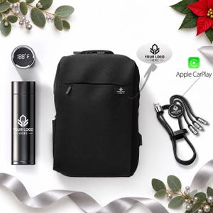 May include: A black backpack, a black vacuum-insulated water bottle with a digital temperature display reading 188°F, and a black multi-port charging cable. Each item features a logo with the text YOUR LOGO HERE.
