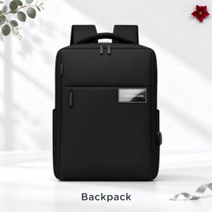 May include: A black backpack featuring a rectangular silhouette, a top handle, and adjustable shoulder straps. The front includes a horizontal zippered pocket and a metallic rectangular plate with the text YOUR LOGO HERE.