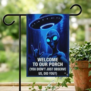 May include: A blue garden flag featuring an alien with glowing eyes and a UFO. The flag reads "WELCOME TO OUR PORCH (YOU DIDN'T JUST OBSERVE US, DID YOU?)". The alien is making a hand gesture. The flag is hanging on a black metal stand.