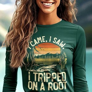 May include: A green long-sleeved shirt with a vintage-style graphic that says "I came, I saw, I tripped on a root".