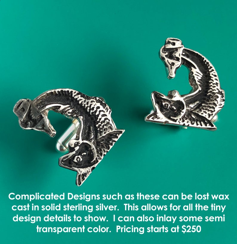 May include: A pair of silver cufflinks featuring a detailed design of two fish intertwined. The cufflinks are cast in solid sterling silver.
