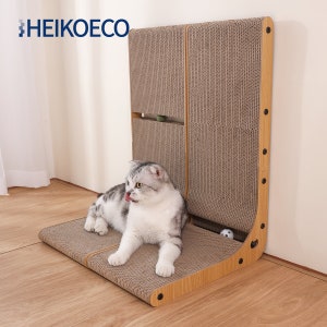 Könnte beinhalten: Ein brauner Karton-Katzenkratzbaum mit einem Holzrahmen und einer Katze, die auf der unteren Plattform liegt. Der Kratzbaum hat ein kleines Loch mit einem Ball darin. Der Text "HEIKOECO" ist in der oberen linken Ecke des Bildes sichtbar.