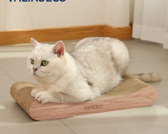 May include: A white cat laying on a brown and beige cardboard scratching post with the text "#HEIKOECO" on the side.