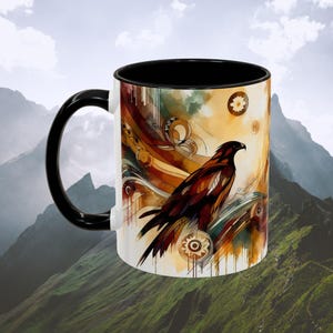 May include: White ceramic mug with a black handle and interior. The mug features a watercolor illustration of a brown and black hawk with abstract, swirling designs in shades of gold, brown, and green.