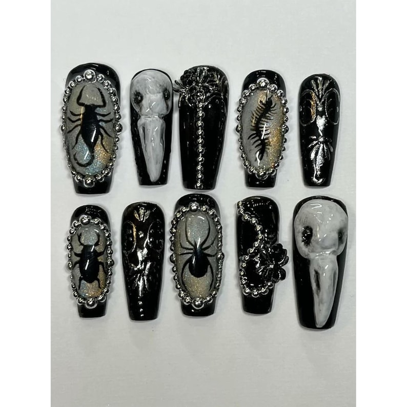 Peut inclure: Ensemble de dix faux ongles noirs avec divers motifs. Chaque ongle pr&eacute;sente une base noire brillante avec des accents argent&eacute;s et blancs. Les motifs incluent des insectes, des araign&eacute;es et des motifs floraux, avec une bordure argent&eacute;e.