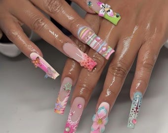 May include: A hand with long, decorated acrylic nails. Designs include butterflies, flowers, stripes, and geometric patterns in pastel pink, blue, green, and white. Some nails feature 3D embellishments like pearls and stars.