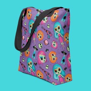 May include: Purple tote bag with a repeating pattern of cartoon alien girls, spaceships, planets, and stars. The girls are wearing pink and blue dresses and have green skin and blue hair.
