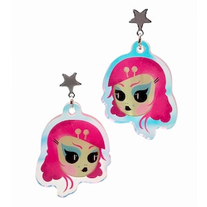 Op de afbeelding: Een paar regenboogkleurige acryl oorbellen met een cartoon alien meisje met roze haar en blauwe ogen. Elke oorbel heeft een zilveren ster bedel aan de bovenkant.