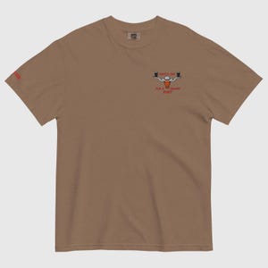 Puede incluir: Camiseta marr&oacute;n con un gr&aacute;fico de dos pintas de cerveza y el texto "Lovely Day for a Creamy Pint". La palabra "Cheer" est&aacute; impresa en la manga izquierda. La camiseta est&aacute; hecha de un material suave.