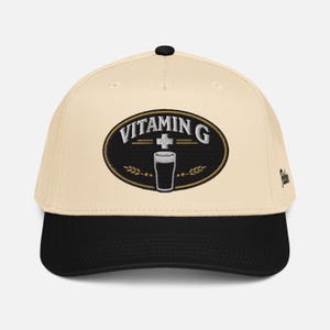 Puede incluir: Gorra de b&eacute;isbol color crema con visera y bot&oacute;n negros. Presenta un parche ovalado bordado con la inscripci&oacute;n "VITAMIN G" y un dibujo de un vaso de pinta. Un accesorio de moda.