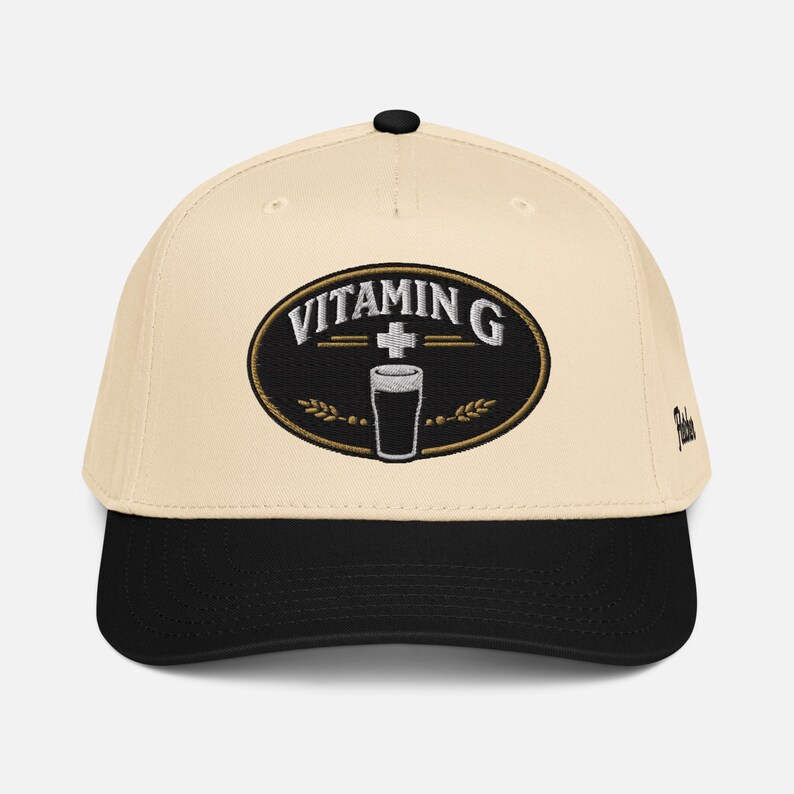 Puede incluir: Gorra de b&eacute;isbol color crema con visera y bot&oacute;n negros. Presenta un parche ovalado bordado con la inscripci&oacute;n "VITAMIN G" y un dibujo de un vaso de pinta. Un accesorio de moda.